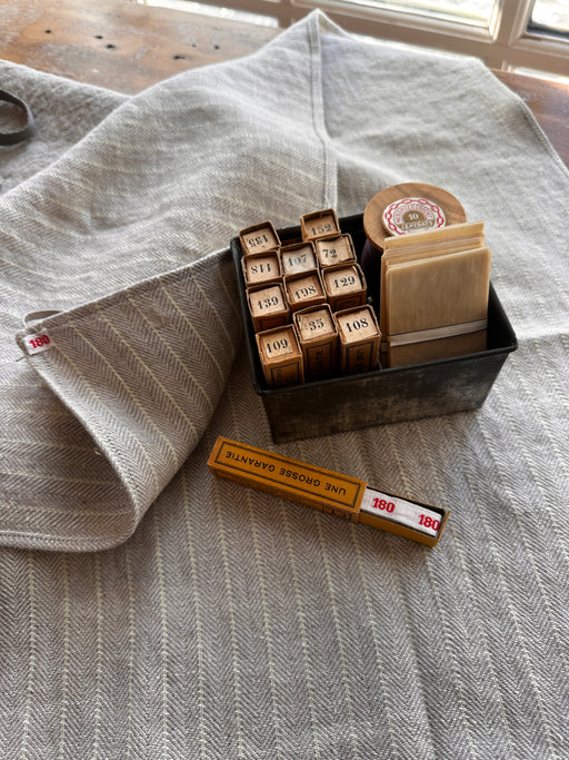 photo of a linen towel with antique linen laundry tags in a box