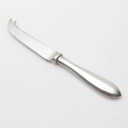 Pewter cheese knife on a light gray background