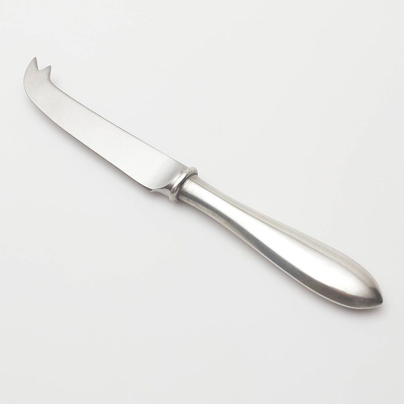 Pewter cheese knife on a light gray background