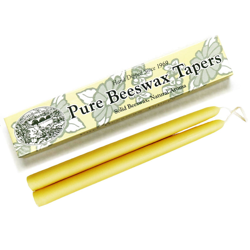 A pair of pure beeswax taper candles next to their packaging, labeled 'Mole Hollow Candles', depicting floral designs.