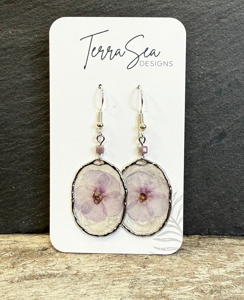 Pair of earrings on a card with 'Terra Sea Designs' branding against a dark background.