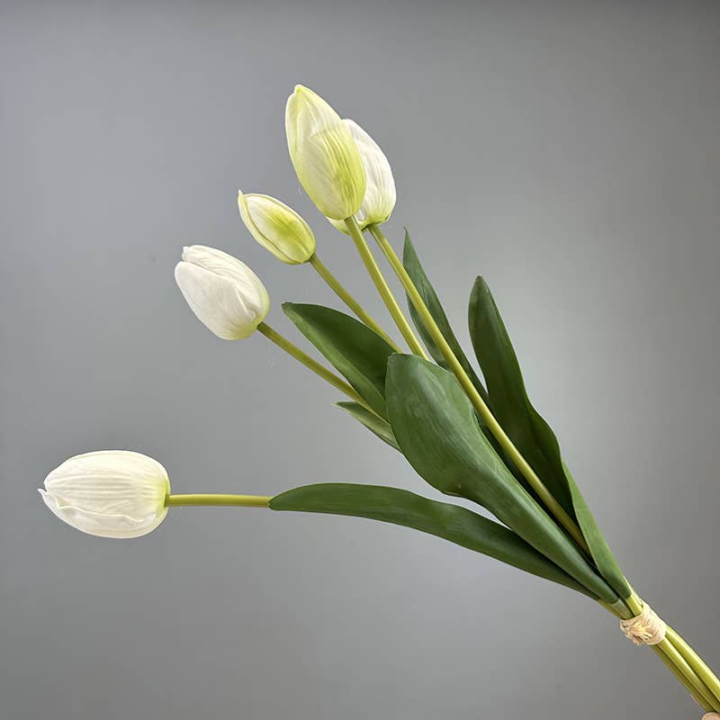 Bouquet of white tulips with green leaves on a gray background - real feel faux tulip looks like from a New England Country garden.