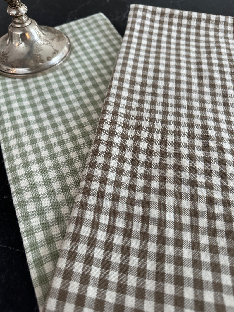 Close-up of brown and white checkered fabric with a metallic object underneath.